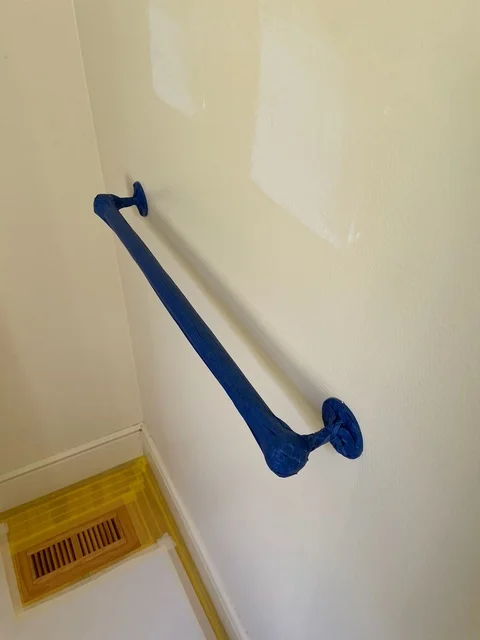 Cream-colored interior wall with navy blue grab bar installed horizontally
