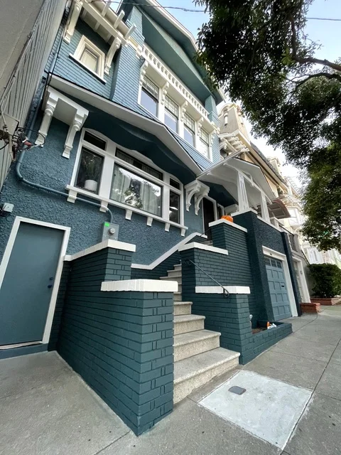 Dark teal painted shingle siding with white trim on multi-story residential home